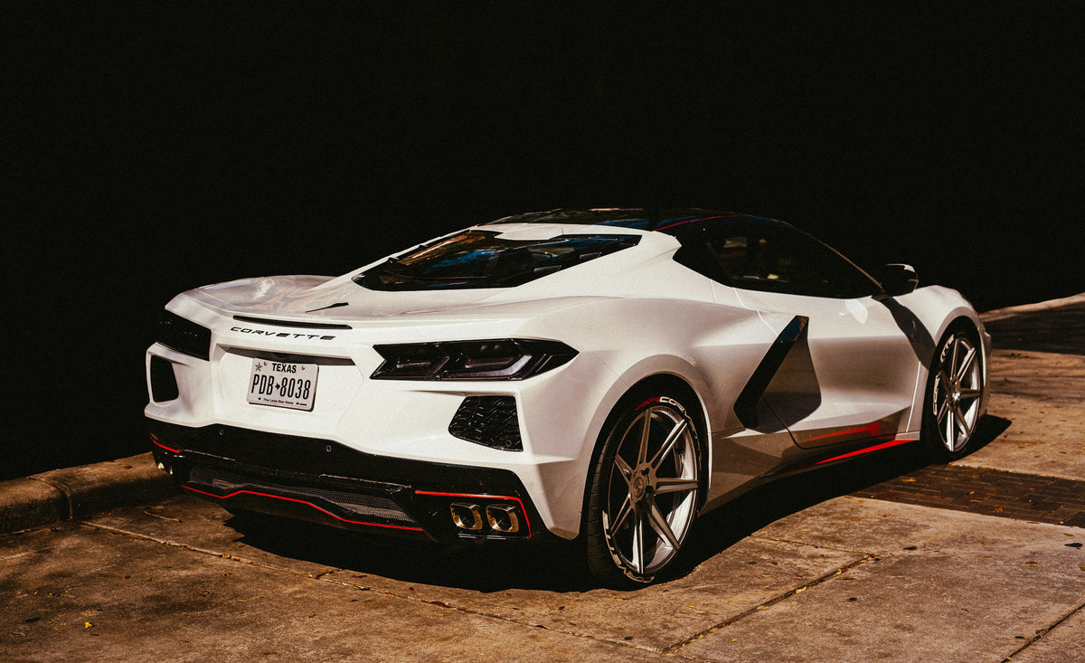 White C8 Corvette rear three-quarter view with quad exhaust tips