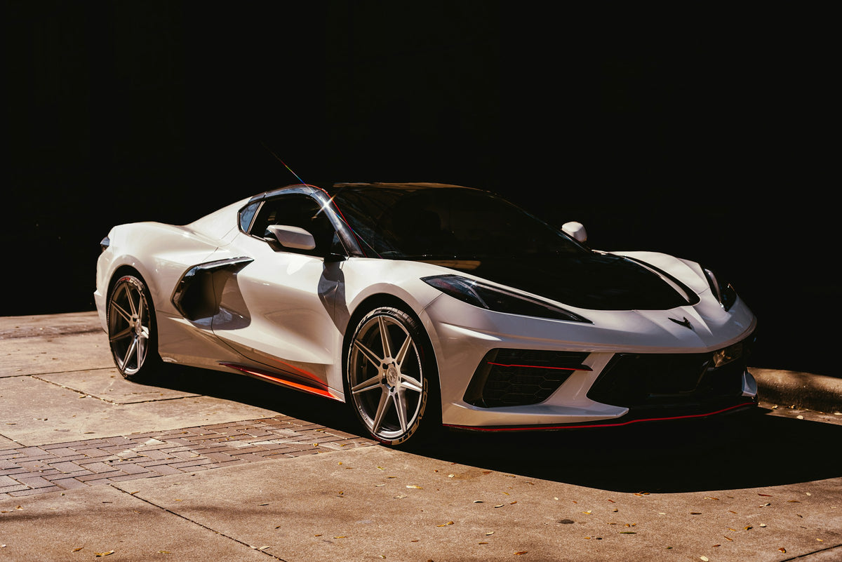 White C8 Corvette Stingray with red accents on a black background