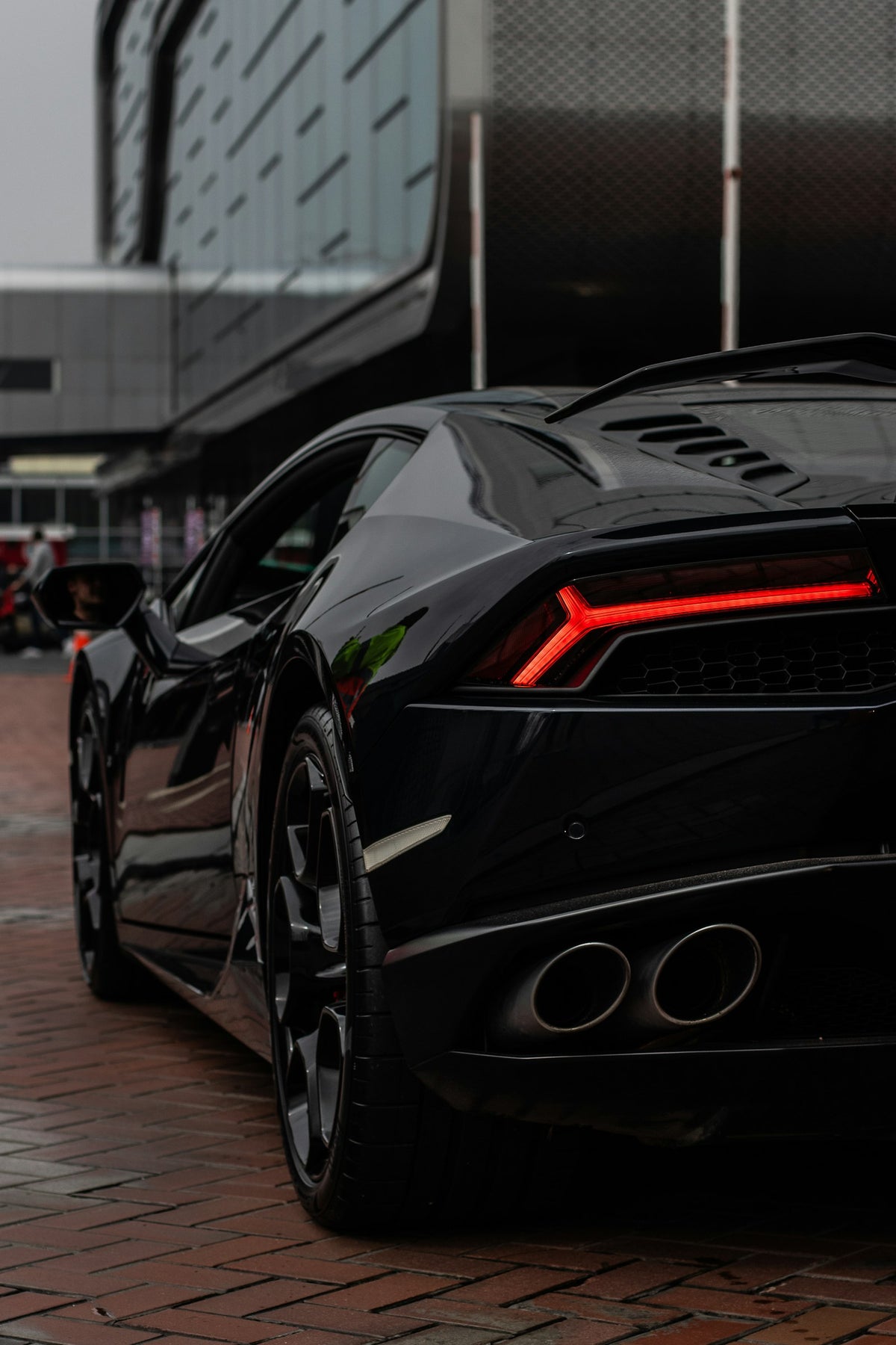 Black Lamborghini Huracan rear with red taillight and exhaust tips